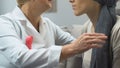 Mammologist comforting breast cancer patient, ensuring effective treatment