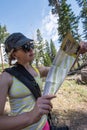 A female hiker attempts to read a map for Devil`s Postpile National Monument and appear Royalty Free Stock Photo