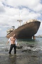 Man with abandoned ship in the seaside
