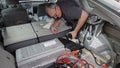 A man accessing the hybrid battery fan Toyota Prius in order to clean it. Photo taken in Vista, CA / USA on June 4, 2020.