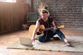 Man acoustic guitar sitting floor with laptop and headphones playing singing song online music lessons Royalty Free Stock Photo