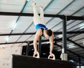 Man, acrobat and gymnastics upside down in balance for fitness practice, training or workout at gym. Professional male