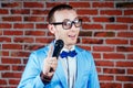 A man actor comedian in glasses, a stylish and tie suit holds a microphone. concept of public speaking Royalty Free Stock Photo