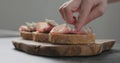 Man add pancetta to slice of ciabatta with fig marmalade Royalty Free Stock Photo