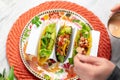 Man adding sauce to his tacos