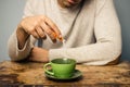 Man adding sugar to his coffee or tea Royalty Free Stock Photo