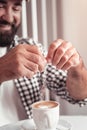 Man adding sugar to his morning coffee Royalty Free Stock Photo