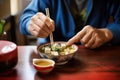 man adding tofu to miso soup, focus on tofu blocks Royalty Free Stock Photo