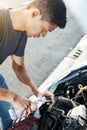 Man adding water to car radiator