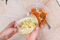 A man adds frozen cabbage to the minced meat for lazy cabbage rolls on the table.