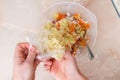 A man adds frozen cabbage to the minced meat for lazy cabbage rolls on the table.