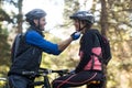 Man adjusting bicycle helmet of a woman