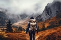 Man admiring beautiful foggy landscape in autumn mountains. Adventurous young man with backpack. Hiking and trekking on a nature Royalty Free Stock Photo