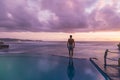 Man admiring sunset standing at an infinite pool Royalty Free Stock Photo