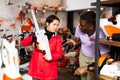 Man advises woman to choose chainsaw at garden tool store Royalty Free Stock Photo