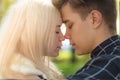 A man affectionately call looks at woman, guy and girl are worth close, touching tips noses. The concept of first teenage love and