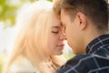 A man affectionately call looks at woman, guy and girl are worth close, touching tips noses. Concept of first teenage love and