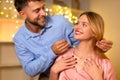 Man affectionately gifting a necklace to a delighted woman Royalty Free Stock Photo