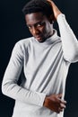 man of african appearance in a gray sweater holding his head fashion studio Royalty Free Stock Photo