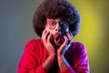 Man with Afro hairstyle confused and shocked with information, looking with astonishment and fear.