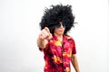 Man with afro wig, sunglasses and hawaiian shirt pointing ahead with boss attitude Royalty Free Stock Photo