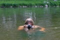 A man aged plunged into the water looking or peeping through a waterproof camera