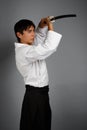 Man in aikido uniform with katana sword