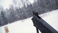 A man aiming a pellet gun towards a target, practicing his aim in the winter. Clip. The shooter in camouflage targets a Royalty Free Stock Photo