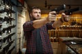 Man aims with two handguns in gun shop Royalty Free Stock Photo