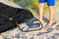 A Man with air foot pump pumps an inflatable mattress or air bed at sandy beach. Foot inflates air mattress with foot pump on sand Royalty Free Stock Photo