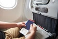 Man in airplane with passport in hand Royalty Free Stock Photo