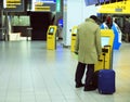 Man at the airport with a suitcase near the terminal to buy ticket