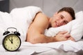 Man with alarm clock in bedroom. Royalty Free Stock Photo