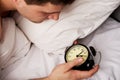 Man with alarm clock in bedroom. Royalty Free Stock Photo