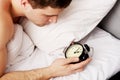Man with alarm clock in bedroom. Royalty Free Stock Photo