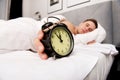 Man with alarm clock in bedroom. Royalty Free Stock Photo
