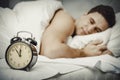 Man with alarm clock in bedroom. Royalty Free Stock Photo