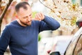 Man allergic suffering from seasonal allergy at spring in blossoming garden. Royalty Free Stock Photo