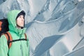 Man alpinist looks up against a winter mountain landscape. Royalty Free Stock Photo