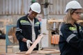 Man American African wearing safety uniform and hard hat working quality inspection of wooden products at workshop manufacturing