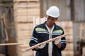 Man American African wearing safety uniform and hard hat working quality inspection of wooden products at workshop manufacturing