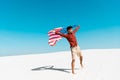 Man with american flag on windy sandy beach