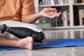 Amputee man with prosthetic leg prosthesis meditating doing yoga at home.