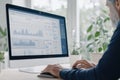 Man analyzes data on computer screen. Businessman works with data dashboard. Graphs, charts show performance. Office environment.