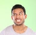 Man, angry face and disgust with awkward humor, comedy or nasty look on a green studio background. Frustrated male Royalty Free Stock Photo
