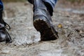 A man in ankle boots walking through the mud, forest road Royalty Free Stock Photo