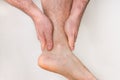 Man with ankle pain holding his aching leg Royalty Free Stock Photo