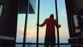 Man in an apartment against background of big city. Handsome man in his room in luxury hotel is looking beautiful Royalty Free Stock Photo