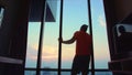 Man in an apartment against background of big city. Handsome man in his room in luxury hotel is looking beautiful Royalty Free Stock Photo