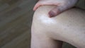 A man applies an anti-inflammatory healing cream to his leg with his hand. Treatment of arthrosis and arthritis, anti